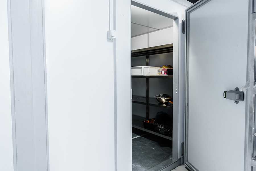 Commercial refrigeration services for walk-in coolers and freezers with open heavy-duty insulated door and stainless steel shelving