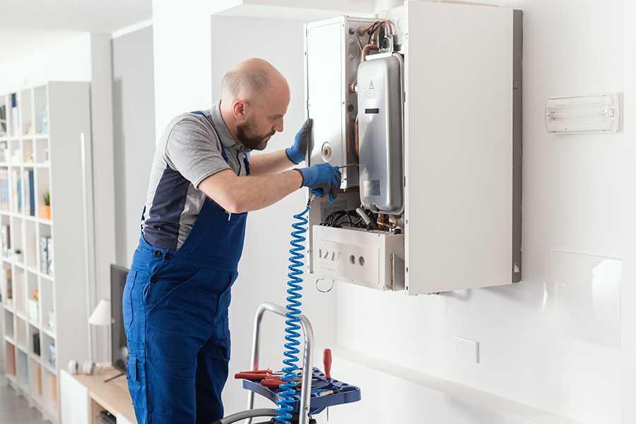 Airtech Mechanical technician servicing a wall-mounted tankless water heater in Livonia, MI